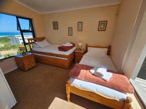 two beds in a room with a view of the ocean at Bee Unique in Sedgefield