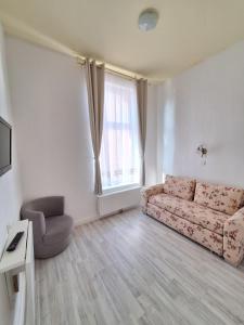 a living room with a couch and a chair at Pension Kapitän Schmuck in Borkum