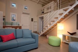 a living room with a blue couch and a staircase at Elies Houses in Agnontas