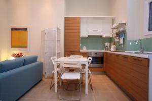 a kitchen with a table and a blue couch at Elies Houses in Agnontas