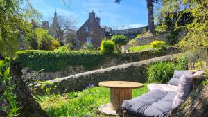 a garden with a table and a bench and a table and a table at LES REMPARTS DU JERZUAL in Dinan
