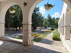 an archway of a building with flowers and a street at Divna in Arandjelovac