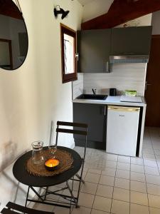 圣马丁阿尔代什Maison avec terrasse et parking, à 350 m de la plage的小厨房配有桌椅和水槽