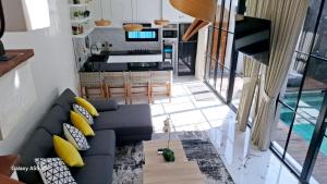 a living room with a blue couch and a kitchen at Vila Cartenz in Jimbaran
