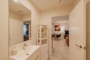 un baño con lavabo y espejo en Central 1BR Apt - Balcony Kitchen & Bath, en Christchurch