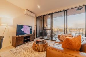 Una sala de estar con un sofá y un televisor. en Central 1BR Apt - Balcony Kitchen & Bath, en Christchurch