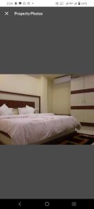 a bedroom with a bed with white sheets and pillows at Hotel Blue Bird Nest in Bumlitan +3 photos