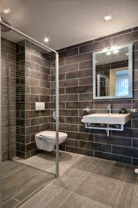 a bathroom with a sink and a toilet and a mirror at B&B La Festa in Amsterdam