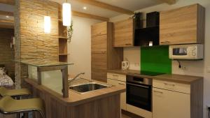 a kitchen with a sink and a microwave at Hiša Lunna - Apartments in a Forest Paradise in Vitanje +12 photos