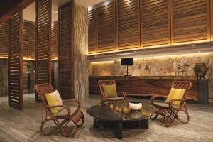 a lobby with chairs and a table and a television at Breathless Cabo San Lucas - Adults Only in Cabo San Lucas