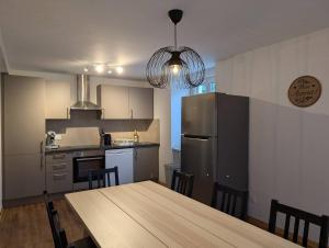 a kitchen with a wooden table and a refrigerator at Grande Maison Familiale in Soultz-Haut-Rhin