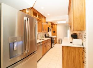 a kitchen with wooden cabinets and a stainless steel refrigerator at Sunnyside Nest in Washington, D.C.