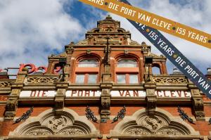 a tall building with signs on the side of it at Hotel Die Port van Cleve in Amsterdam