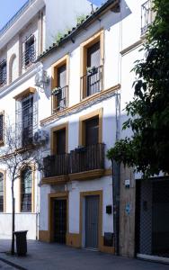 ein weißes Gebäude mit Fenstern und Balkonen in der Unterkunft El Rincón de Pilar in Córdoba