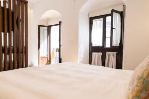 ein Schlafzimmer mit einem weißen Bett und einem Spiegel in der Unterkunft El Rincón de Pilar in Córdoba