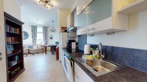 Una cocina con fregadero y una sala de estar. en Verdi in der Villa Patricia, en Borkum