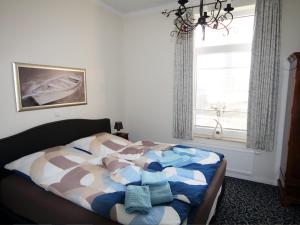 una cama en un dormitorio con ventana en Verdi in der Villa Patricia, en Borkum