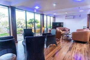 a room with chairs and a living room with windows at Marine Sky Apartment in Maggona West
