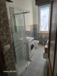 a bathroom with a washing machine and a washer at Casa Amy in Acqui Terme +5 photos