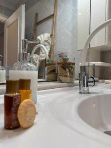 a bathroom sink with a bottle of soap and a soap dispenser at Villa Angelo Porto Heli - Private Pool in Porto Heli