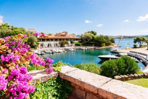 a view of a marina with purple flowers at Hotel Palumbalza Porto Rotondo in Porto Rotondo