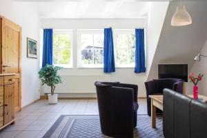 a living room with blue curtains and a table and chairs at Ferienwohnung Ferienhäuser am Brocken, 80 qm 3 Schlafzimmer in Ilsenburg