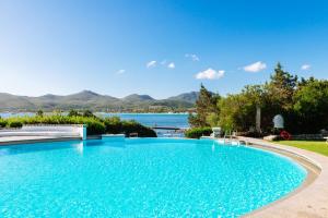 a large swimming pool with a view of the water at Hotel Palumbalza Porto Rotondo in Porto Rotondo
