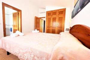 a bedroom with a large white bed in a room at Villa Mar in Cala en Bosc