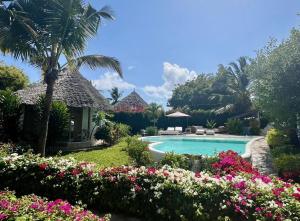 a resort with a swimming pool and some flowers at Dama Villa in Watamu