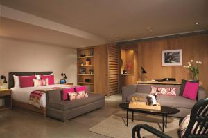 a bedroom with a bed and a living room at Breathless Cabo San Lucas - Adults Only in Cabo San Lucas