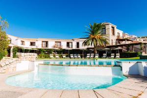 a swimming pool in front of a house at Hotel Palumbalza Porto Rotondo in Porto Rotondo