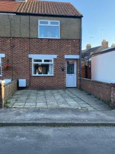 a brick house with a white door and a window at Valeries House 4 Bed 2 Bath close to beach in Gorleston-on-Sea