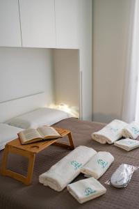 a bed with towels and a table with a book at Colè House in Bitetto