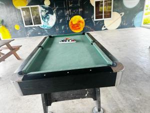 a green pool table in a room with a wall at Galaxy Villa room in Dalaguete