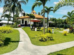 a walkway in front of a house with palm trees at Galaxy Villa room in Dalaguete