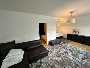 salon z czarną skórzaną kanapą i sypialnią w obiekcie Loft Living - Köln - Ehrenfeld w Kolonii