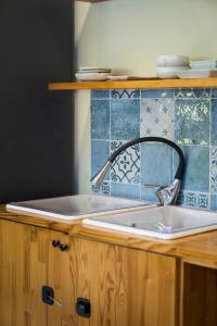 eine Küchenspüle mit blauen Fliesen an der Wand in der Unterkunft Hongdae, Private Flats in Seoul