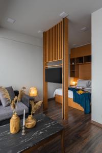 Una sala de estar con una cama, un sofá y una mesa. en Sweet Home Deluxe Apart-Hotel, en Ereván