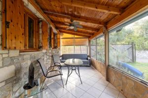a patio with a ceiling fan and a table and chairs at Relaxing Stone Cottage in Aigio