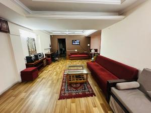 インドールにあるThe Guest Houseの赤いソファとテーブルのあるリビングルーム