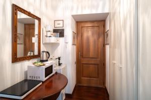 a room with a microwave on a table with a mirror at Pool and Relax at Casa Ilenia in Bordighera