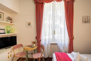 a bedroom with a bed and a window with red curtains at Pool and Relax at Casa Ilenia in Bordighera
