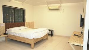 a bedroom with a bed and a television in a room at Gauri Resort in Pune