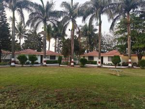 a house with palm trees in front of a park at Gauri Resort in Pune