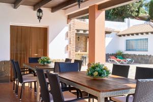 an outdoor patio with wooden tables and chairs at Villa Alejandro En Sayalonga in Sayalonga