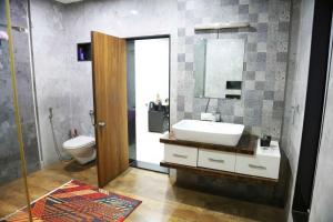 a bathroom with a sink and a toilet and a mirror at 1 BHK luxury Bedroom Penthouse ,Couple Friendly in Belgaum +16 photos