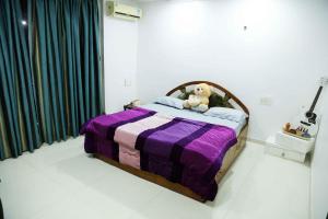 a bedroom with a bed with a teddy bear on it at 1 BHK luxury Bedroom Penthouse ,Couple Friendly in Belgaum