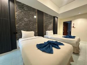 Koh Chang Cabana Resort with swiming pool في كو تشانغ: سريرين في غرفة الفندق عليها مناشف زرقاء