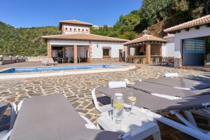 a villa with a swimming pool and a house at Villa Alejandro En Sayalonga in Sayalonga