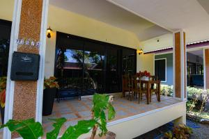 een veranda van een huis met een tafel en stoelen bij Baan Peaceful Villa 2, Ao Nang in Krabi town